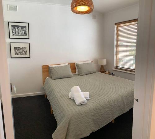 a bedroom with a bed with two towels on it at Yarrumla Beach Lodge in Somerton Park