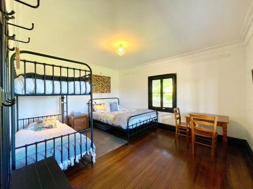 a bedroom with two bunk beds and a table at Linden Lodge in Linden