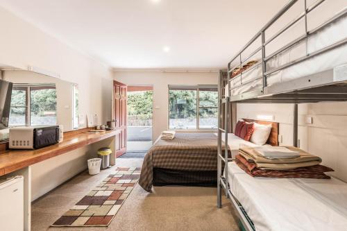 two bunk beds in a room with a kitchen at Black Forest Motel in Macedon