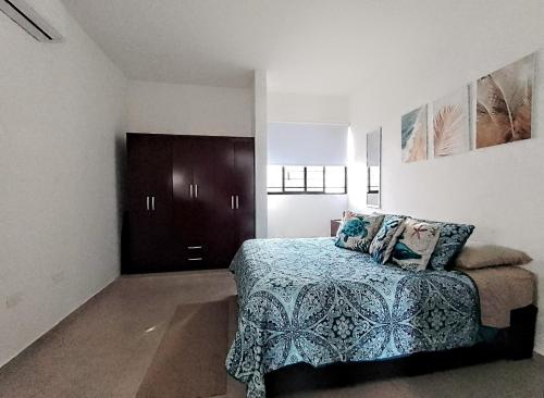 sypialnia z łóżkiem z niebieskim kocem w obiekcie Casa en privada con alberca, Excelente para vacaciones y descanso w mieście Playa del Carmen