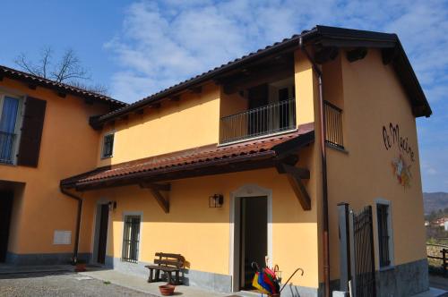 a yellow building with a porch and a balcony at Le Macine Relais in Cairo Montenotte
