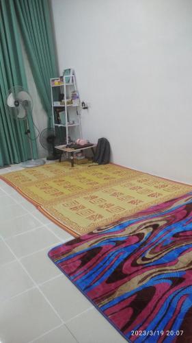 a room with a bed with a rug on the floor at Rumah Lunas in Lunas