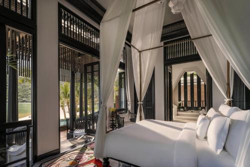 a bedroom with a bed with white pillows at InterContinental Danang Sun Peninsula Resort, an IHG Hotel in Danang