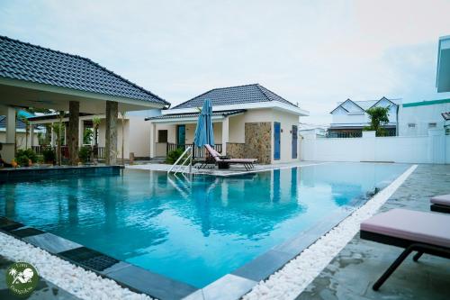 a swimming pool in front of a house at LAM BUNGALOW Resort & Spa in Phu Quoc