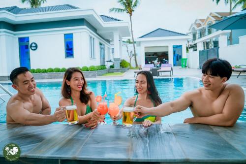 a group of people sitting around a table in a swimming pool at LAM BUNGALOW Resort & Spa in Phu Quoc