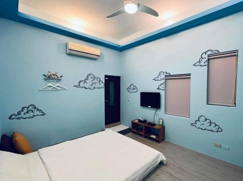 a bedroom with a bed and a blue wall at Divewhale Homestay in Xiaoliuqiu