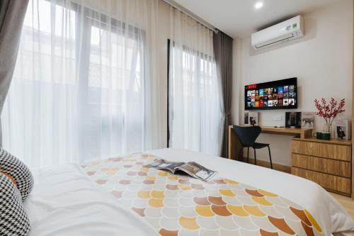 a bedroom with a bed and a window and a desk at Myrcella Urban Studio in Hanoi