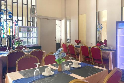 a restaurant with tables and chairs with flowers on them at Urbanview Hotel Harapan Palopo in Palopo