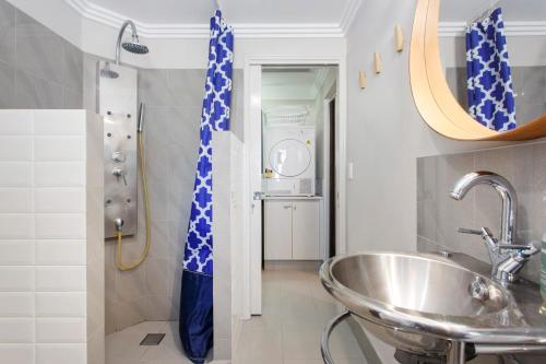 ein Bad mit einem Waschbecken, einer Dusche und einem Spiegel in der Unterkunft Bambino 438 in Perth