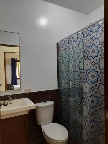 a bathroom with a toilet and a shower and a sink at Sunset Beach House Siargao Sta Fe, General Luna in General Luna