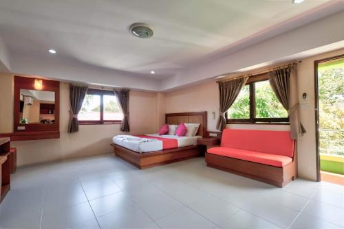 Habitación grande con 2 camas y sofá rojo. en Rak Samui Residence, en Bophut 