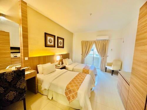 a hotel room with two beds and a bathroom at Rompin Beach Resorts in Kuala Rompin