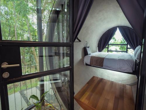 a bedroom with a bed and a large window at The Culvert in Kuching