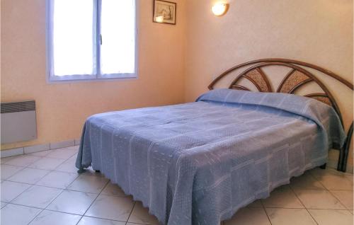 een slaapkamer met een bed met een blauwe deken erop bij Stunning Home In La Faute Sur Mer With Kitchen in La Faute-sur-Mer