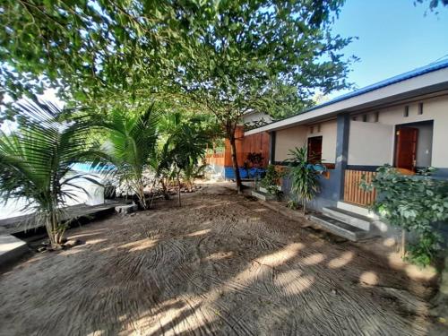 a yard with palm trees in front of a house at Bunaken Sunrise Beach in Manado