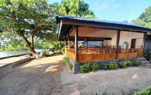 a building with a porch next to a body of water at Bunaken Sunrise Beach in Manado