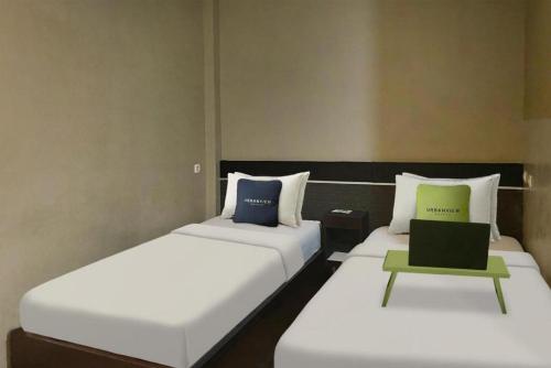 two beds sitting next to each other in a room at Urbanview Hotel Sabang Land Syariah Jayapura in Jayapura