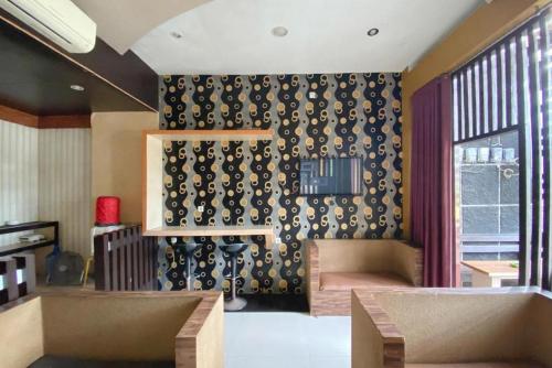 ein Wohnzimmer mit einer schwarz-weiß gemusterten Wand in der Unterkunft Urbanview Hotel Sabang Land Syariah Jayapura in Jayapura