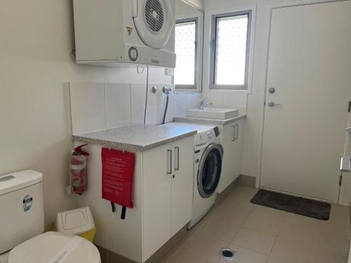 a bathroom with a washing machine and a sink at Seadaze 1 Rainbow Beach in Rainbow Beach