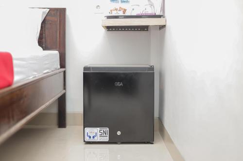 a small appliance sitting on the floor next to a bed at RedDoorz @ Gedangan Sidoarjo in Sidoarjo