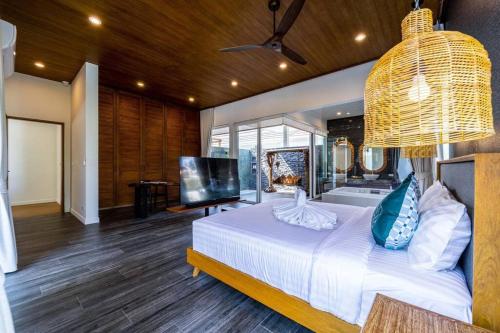 um quarto com uma grande cama branca e uma televisão em Luxury 7 Bedroom Pool Villa WL67 em Hua Hin