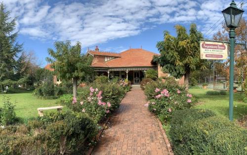 a brick path leading to a house with flowers at Forgandenny House B&B in Mudgee