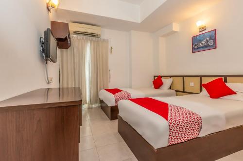 a hotel room with two beds and a flat screen tv at Hash House Hotel in Melaka