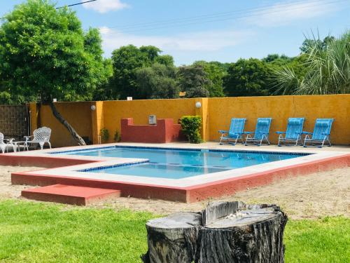 a swimming pool with blue chairs in a yard at GardenView Holiday Home in Maun