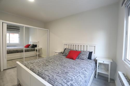 sypialnia z dużym łóżkiem i czerwoną poduszką w obiekcie Nur Apartment w mieście Terrassa