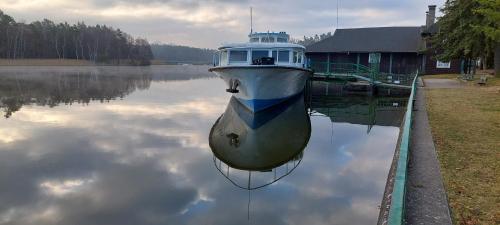 a boat is docked in the water next to a house at Apartmány Kousek od jezera in Doksy