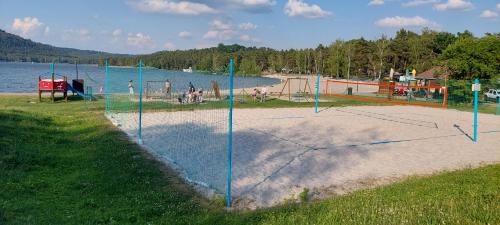 a volleyball court on a beach next to a lake at Apartmány Kousek od jezera in Doksy