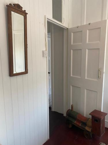 an empty room with a door and a mirror at The Painter’s Retreat in Lower Boscaswell
