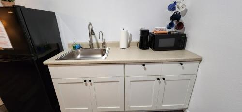 a kitchen counter with a sink and a microwave at #5 New! Cozy Getaway Hot Spot Hilo Keaau Big Island of Hawaii Self CheckIn Studio Apt in Keaau