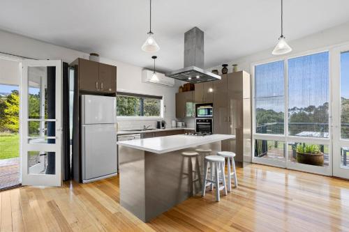 a kitchen with stainless steel appliances and large windows at Dairy House- an idyllic country escape, Daylesford in Daylesford