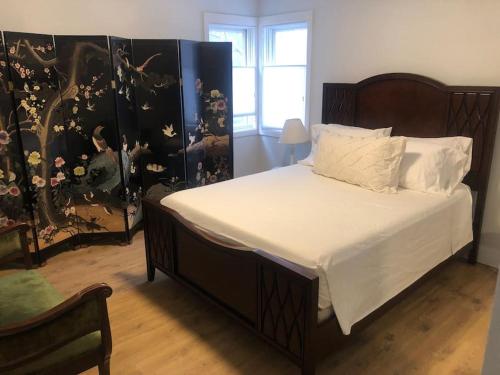 - une chambre dotée d'un grand lit avec des draps et des oreillers blancs dans l'établissement Modern condo steps from the ocean, à Anchorage