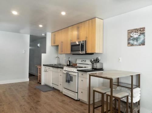 a kitchen with white appliances and a table with chairs at Modern condo steps from the ocean in Anchorage