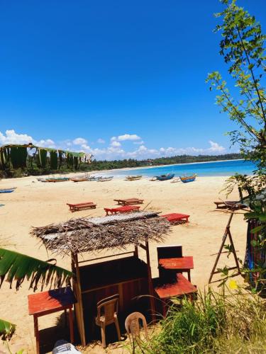 a beach with tables and chairs on the sand at Talalla Wonder View in Talalla South