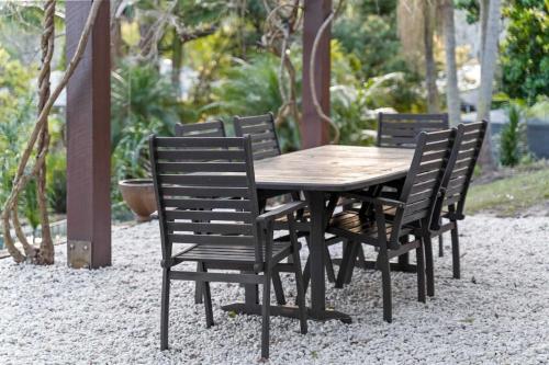 a wooden table and chairs in a garden at Moroccan Acreage -Heated Pool w Slide -PlayBarn in Holgate