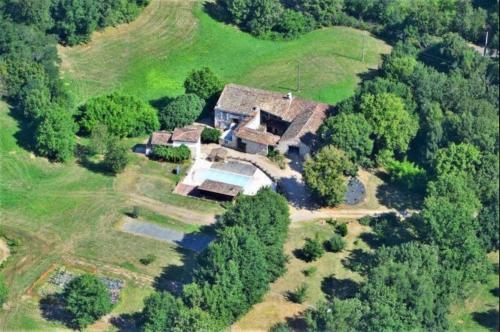 una vista aérea de una casa en una colina con árboles en La Ferme Parrinet - Gîte et Chambres d'hôtes, en Saint-Martin-Laguépie