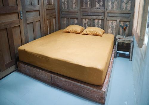 a bed with two pillows on it in a room at Omah Bagelen Homestay 