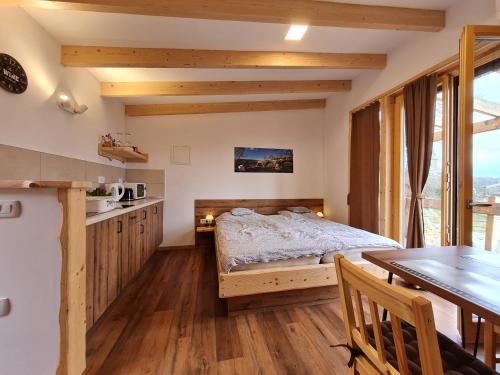 Cet appartement comprend une chambre avec un lit et une table ainsi qu'une cuisine. dans l'établissement Panorama glamping Vipavska dolina, à Dobravlje
