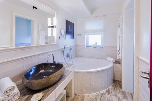 ein Badezimmer mit einer großen Badewanne und einem Waschbecken in der Unterkunft Landhotel Restaurant zur Krone in Gottenheim