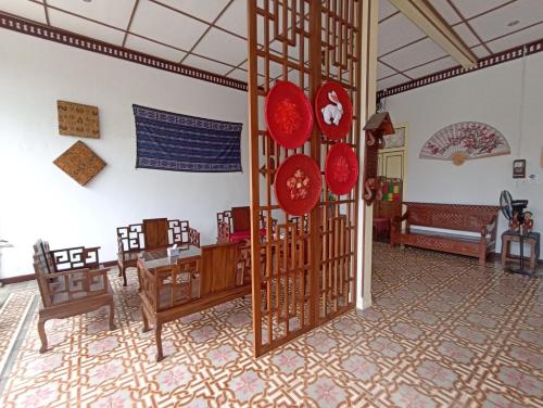 a dining room with a table and chairs and red decorations at Mruyung Guest House Kota Lama Banyumas Mitra RedDoorz in Banyumas