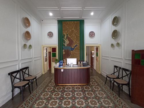 a lobby with a desk and chairs in a room at Mruyung Guest House Kota Lama Banyumas Mitra RedDoorz in Banyumas