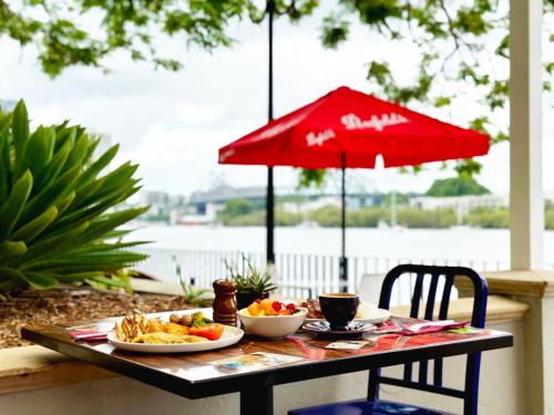 a table with plates of food and a red umbrella at Stamford Plaza Brisbane in Brisbane