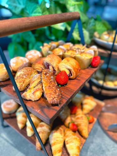 a bunch of different types of bread and pastries on a shelf at Stamford Plaza Brisbane in Brisbane