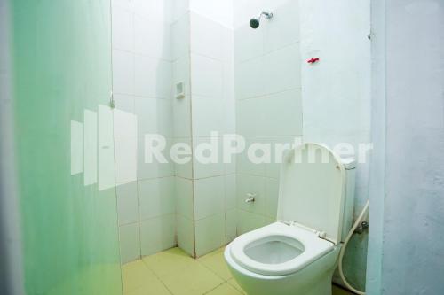 y baño con aseo blanco en una cabina. en Vania Guesthouse near RS Adam Malik Medan RedPartner en Medan