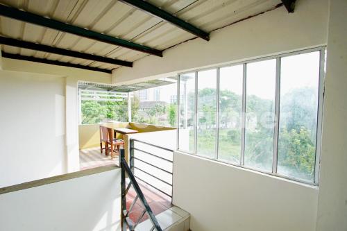 Habitación con paredes blancas y ventanas grandes. en Vania Guesthouse near RS Adam Malik Medan RedPartner en Medan