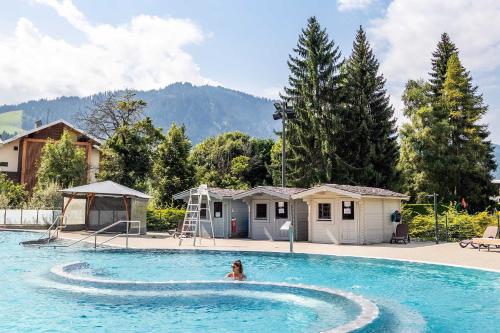 une femme nageant dans une piscine dans l'établissement Megève - Appartement 2 chambres - Proche Centre et Pistes - Fibre - Parking, à Megève