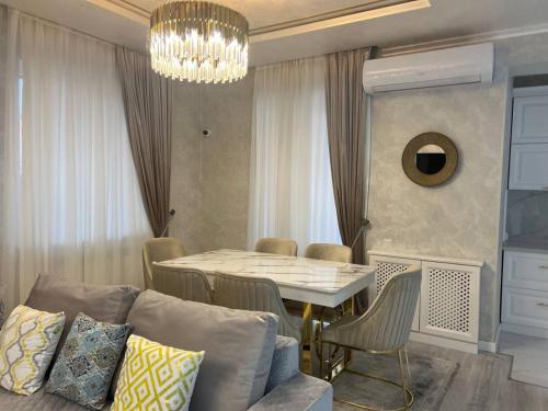 uma sala de estar com uma mesa e um sofá em lux apartment in tashkent city em Tashkent